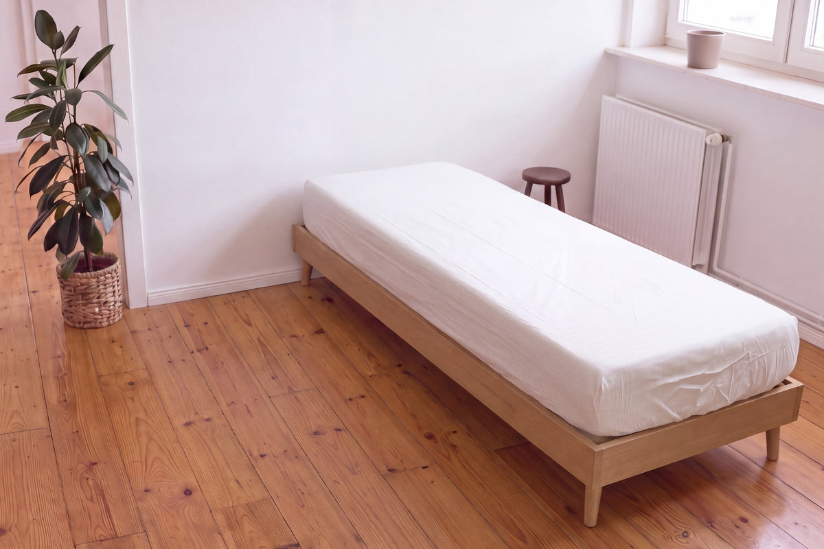Earthle earthing fitted sheet on a single bed on a wooden floor, 200 x 90 x 30 cm