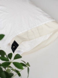 Two Earthle earthing pillowcases side by side, with the press stud for the cable
