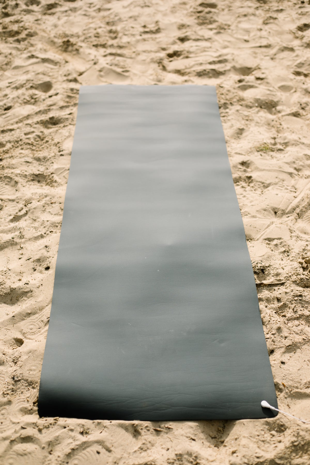Earthle earthing yoga mat rolled out on the sand