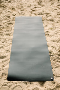 Earthle earthing yoga mat rolled out on the sand