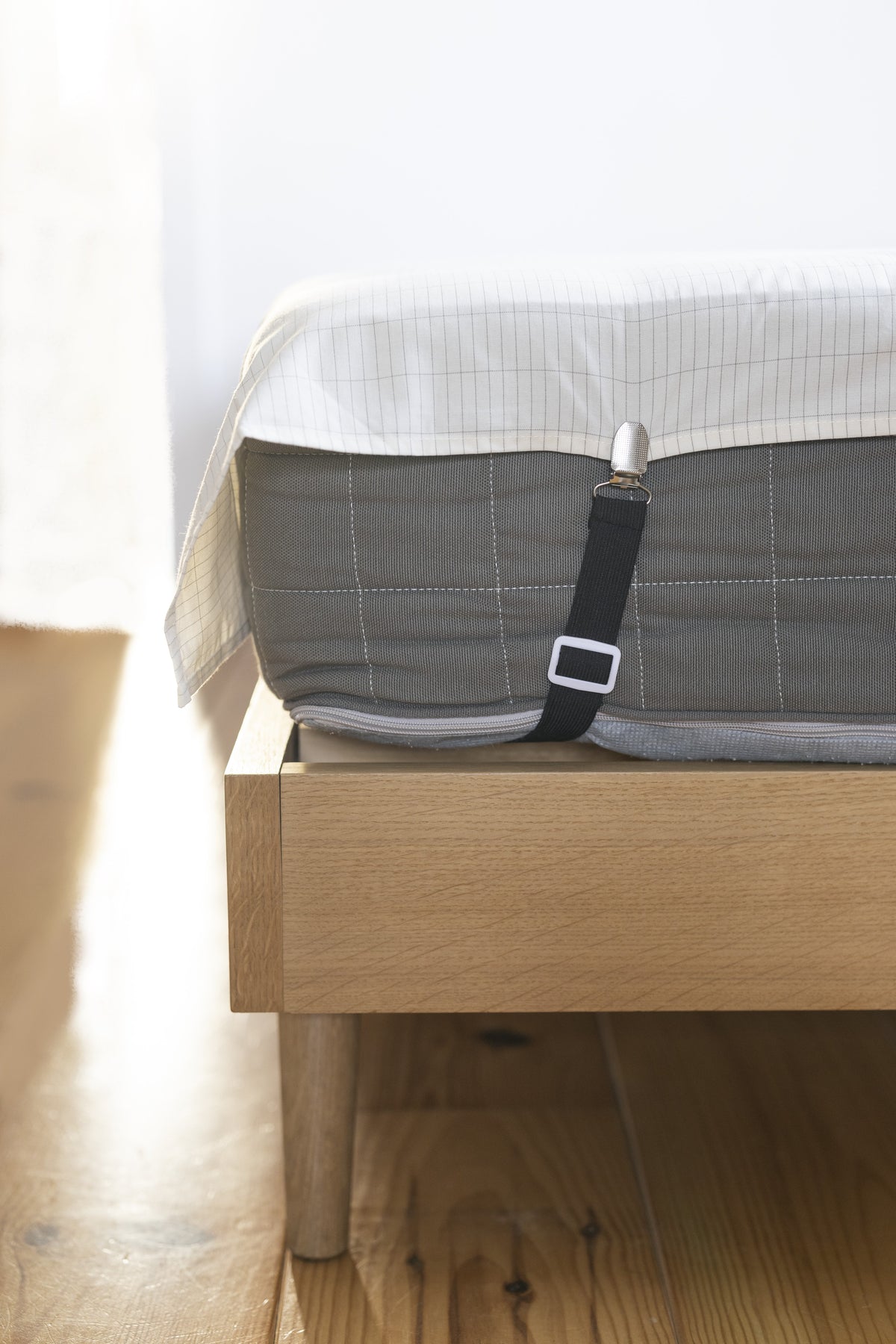 Earthle sheet strap on the corner of a mattress, holding the earthing sheet in place