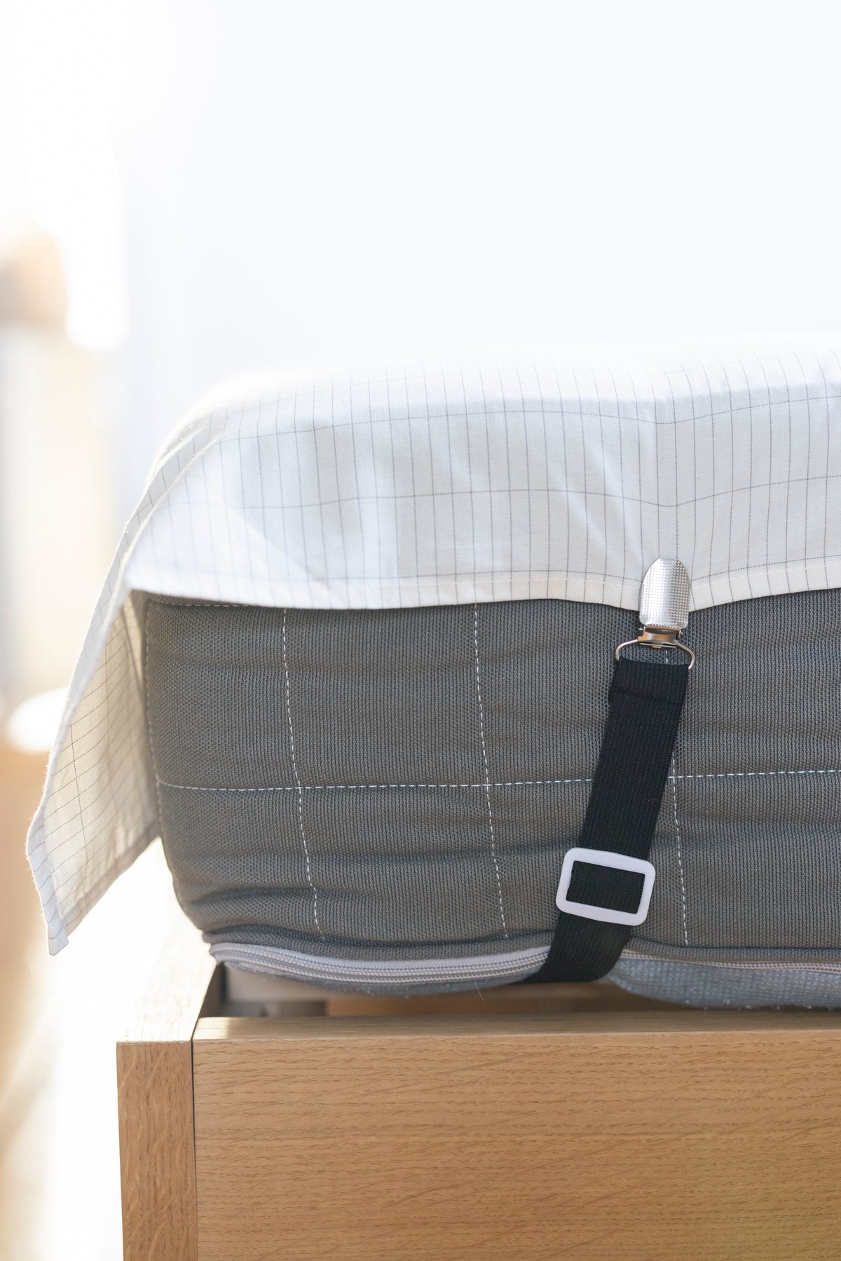 Close-up of the clip of an Earthle sheet strap on the edge of the earthing sheet
