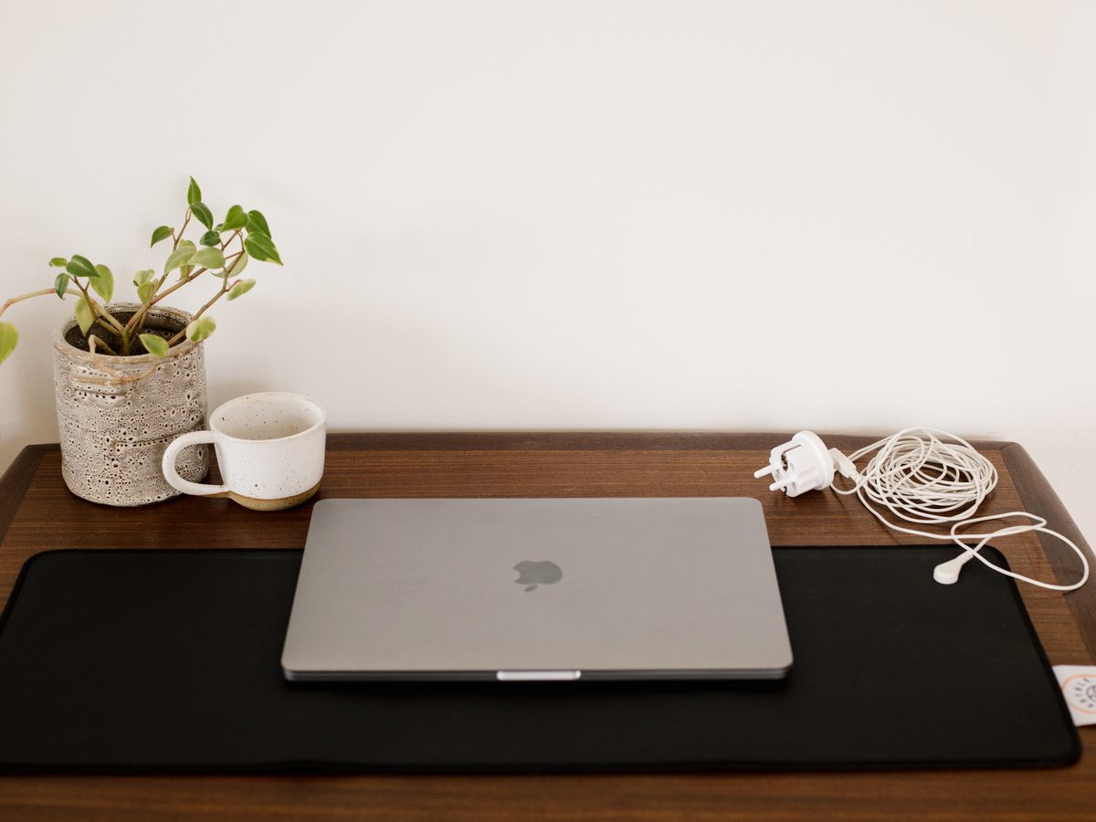 Aardings bureaumat op een bureau met laptop en kabel