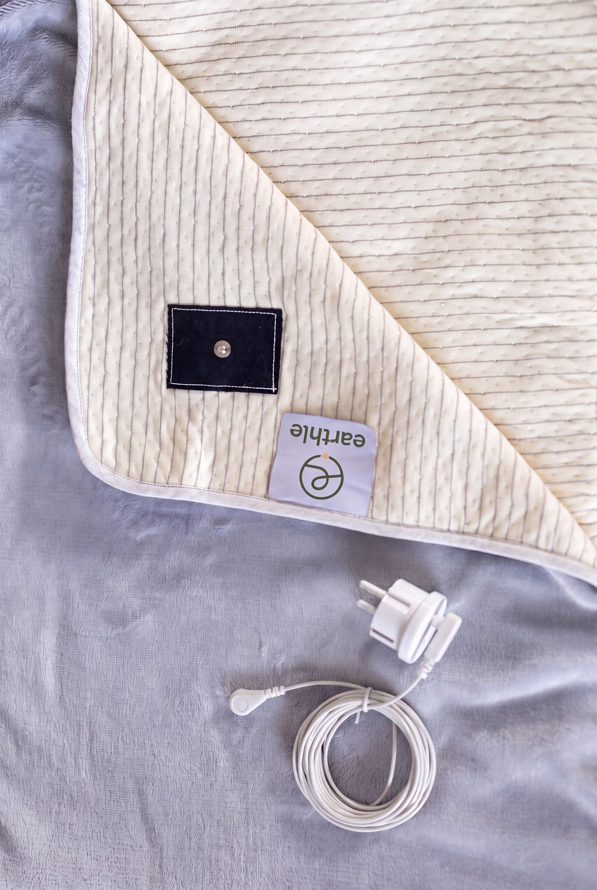 Earthle earthing blanket folded back with the press stud, the plug and the earthing cable, 203 x 152 cm