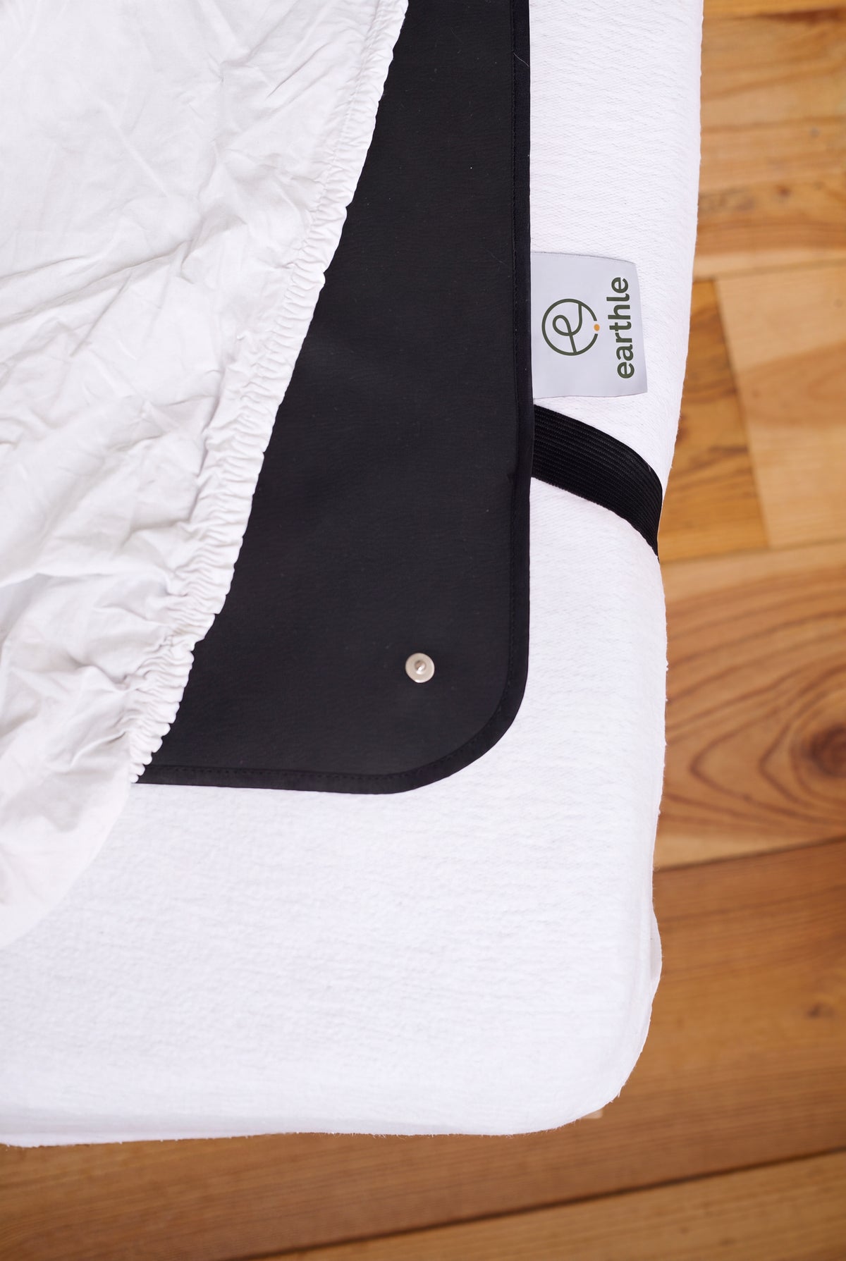 Corner of the Earthle earthing sleeping mat with the strap around the mattress, 185 x 137 cm