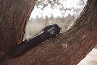 Earthle earthing yoga mat in its carry bag against a pine trunk