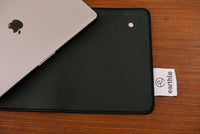 Earthle earthing desk mat from above on a wooden desk, with a laptop and the brand label