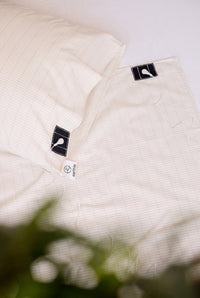Close-up of the press stud on the Earthle earthing pillowcase, showing the woven silver grid in the cotton